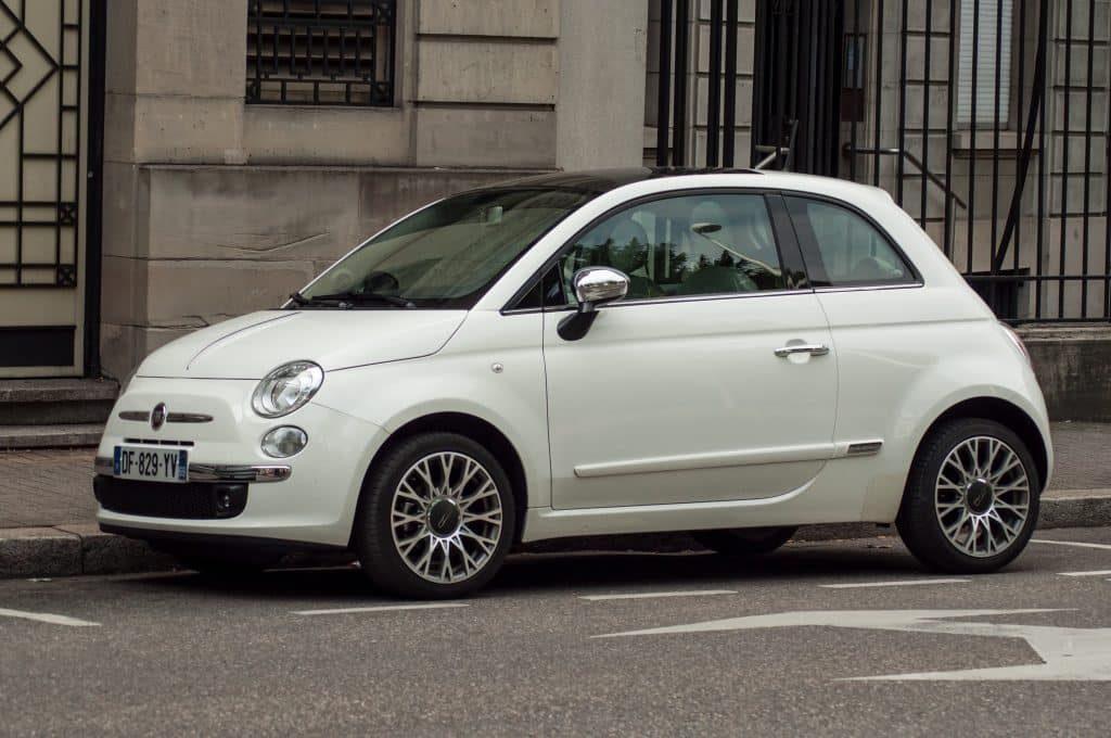 White Fiat parked on the side of the road in France.