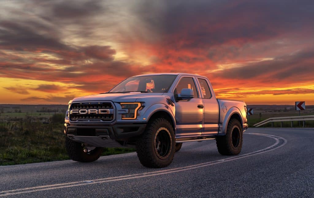 Silver 2020 Ford F-150 parked on a winding road at sunset. 