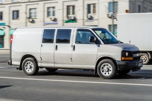 Grey Chevrolet Express driving on the street.