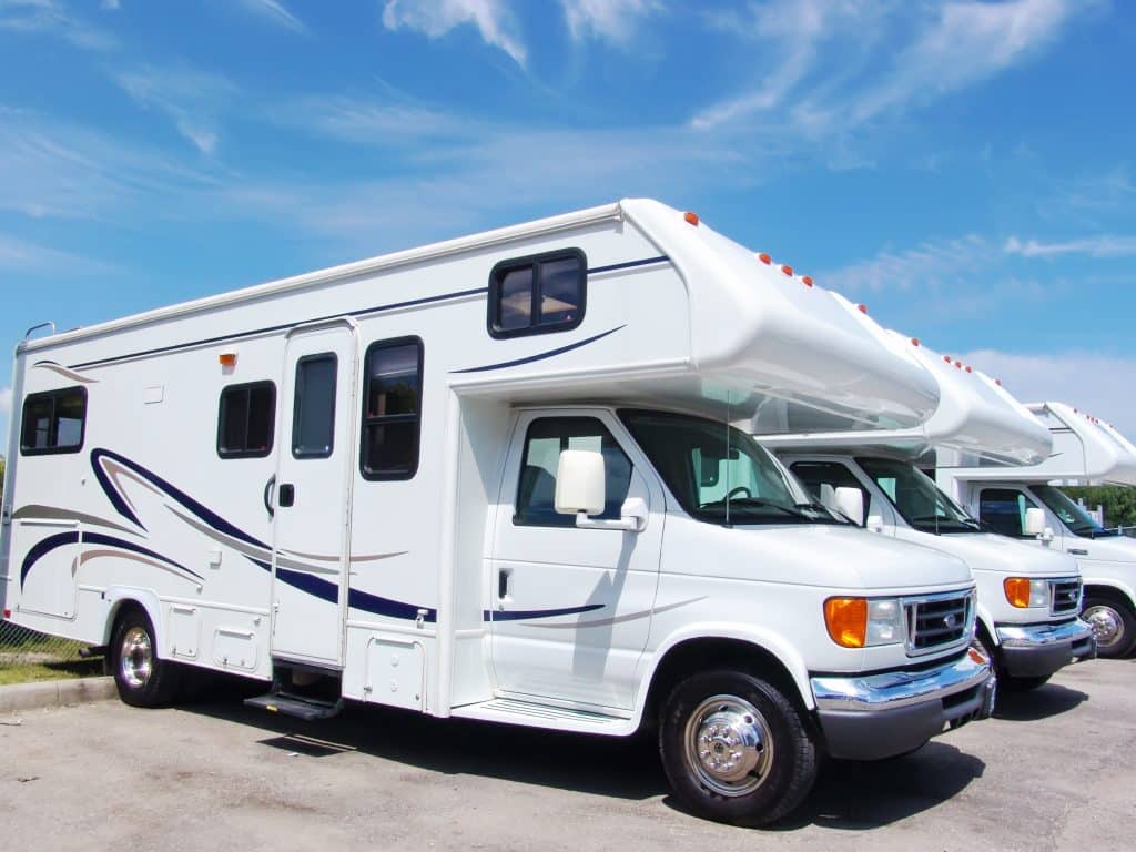 A line of white and blue parked motorhomes.